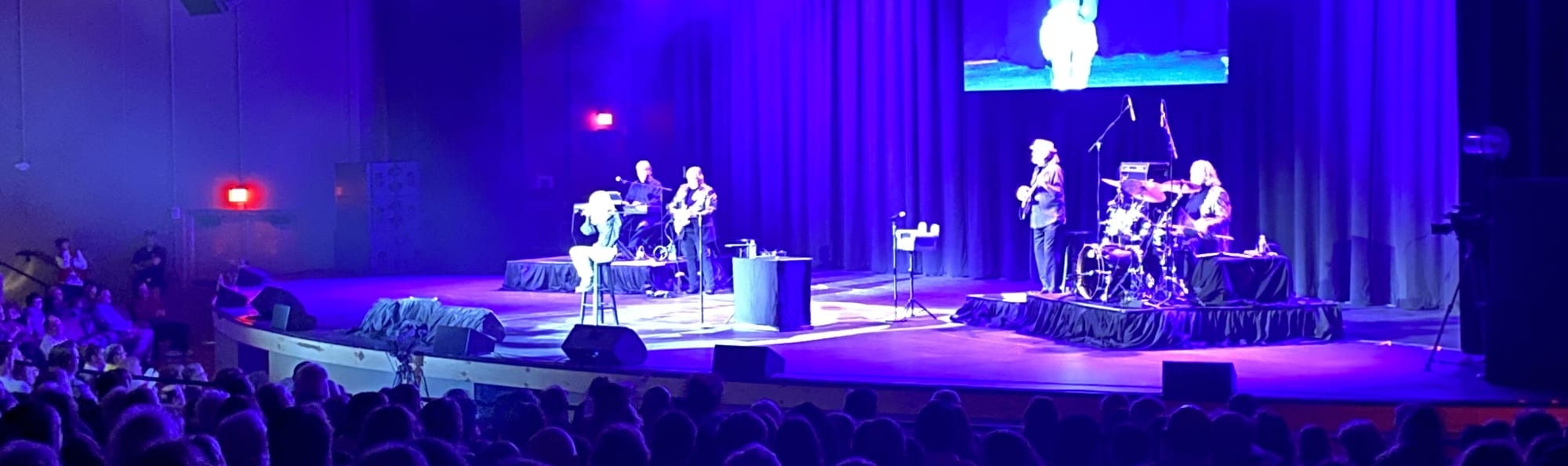 signer on stage in chair washed out by the lights Boston